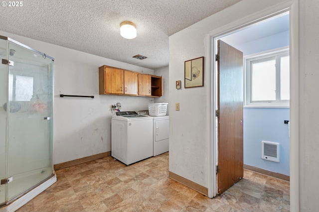 laundry area featuring cabinet space, baseboards, a textured ceiling, and separate washer and dryer