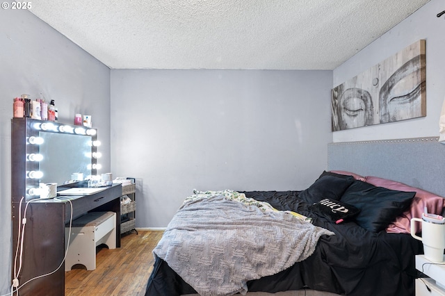 bedroom with a textured ceiling and wood finished floors