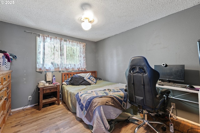 bedroom with a textured ceiling and wood finished floors