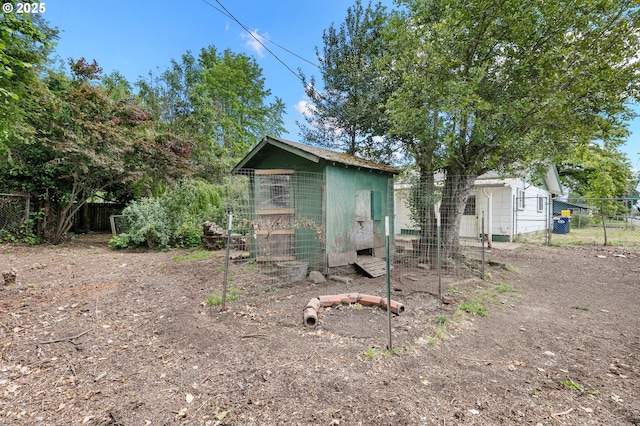 view of side of home with exterior structure, fence, and an outbuilding