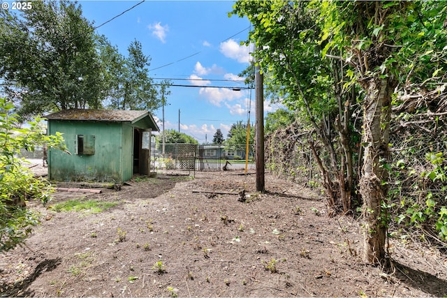 view of yard featuring fence, an outdoor structure, and a storage shed