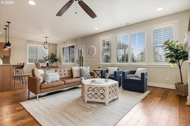 living room with ceiling fan and light hardwood / wood-style floors