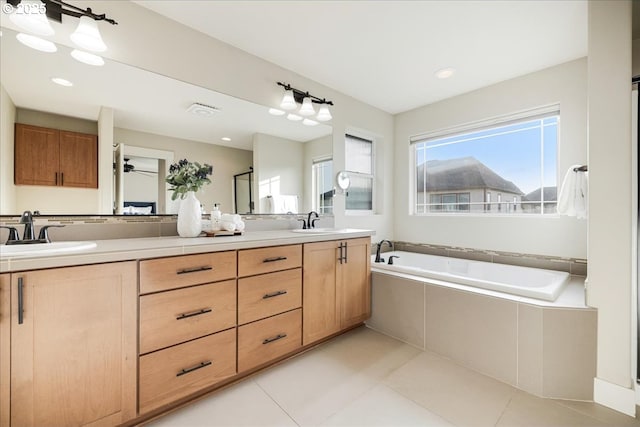 bathroom with tiled bath, tile patterned flooring, and vanity