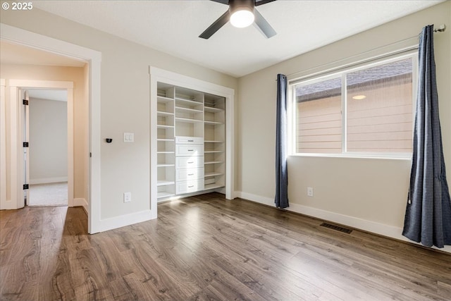 unfurnished bedroom with hardwood / wood-style floors, a closet, and ceiling fan