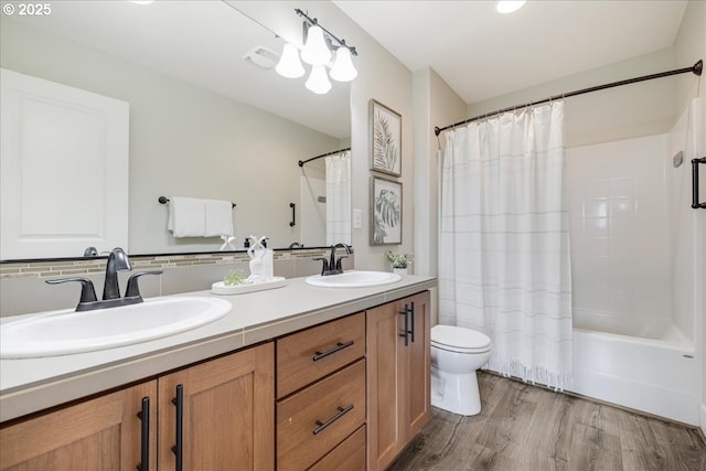 full bathroom featuring toilet, wood-type flooring, vanity, and shower / tub combo with curtain