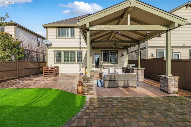 rear view of property featuring a gazebo, a patio, an outdoor living space, and ceiling fan