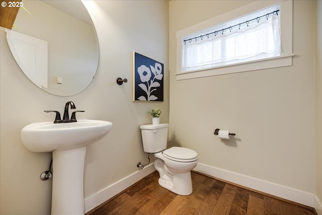 bathroom featuring toilet, wood-type flooring, and sink