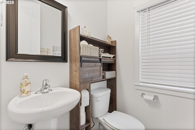 half bath featuring toilet and a sink