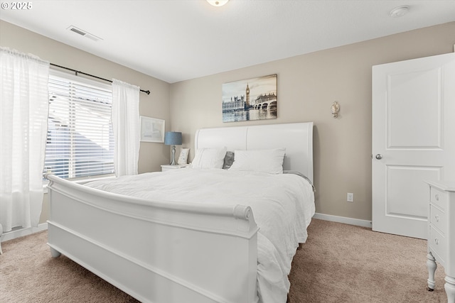 carpeted bedroom featuring visible vents and baseboards