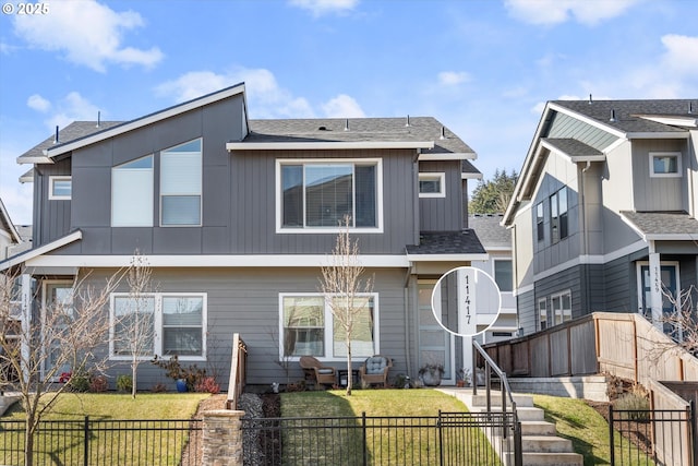 view of front of home featuring a fenced front yard, a front yard, and roof with shingles