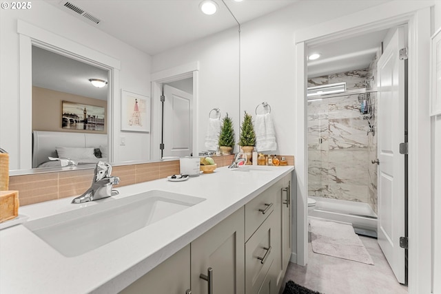 bathroom with double vanity, a stall shower, and a sink