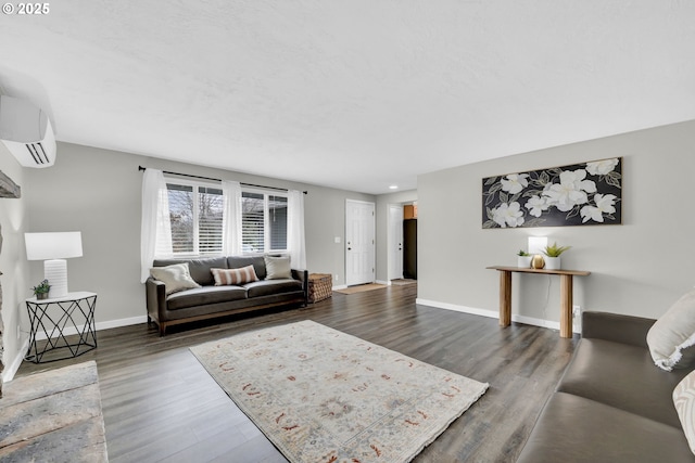 living room featuring a wall unit AC, dark wood finished floors, and baseboards