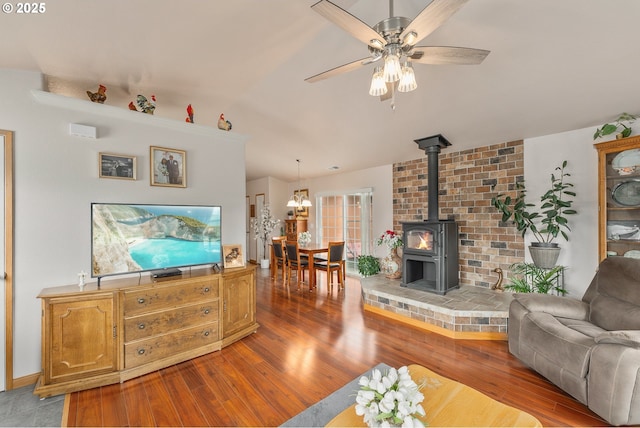 13130 Lookingglass Rd, Winston, OR 97496 - living room with wood finished floors, a wood stove, and ceiling fan with notable chandelier