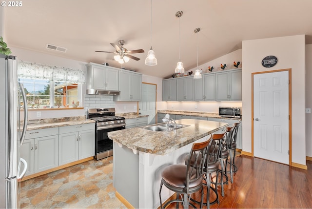 13130 Lookingglass Rd, Winston, OR 97496 - kitchen with a sink, under cabinet range hood, stainless steel appliances, a kitchen island with sink, and visible vents