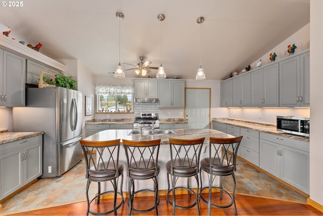 13130 Lookingglass Rd, Winston, OR 97496 - kitchen with gray cabinets, ceiling fan, under cabinet range hood, and stainless steel appliances