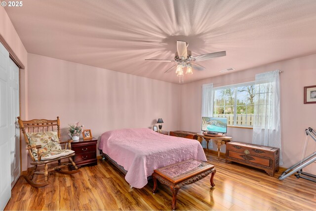 13130 Lookingglass Rd, Winston, OR 97496 - bedroom featuring visible vents, a closet, wood finished floors, and ceiling fan