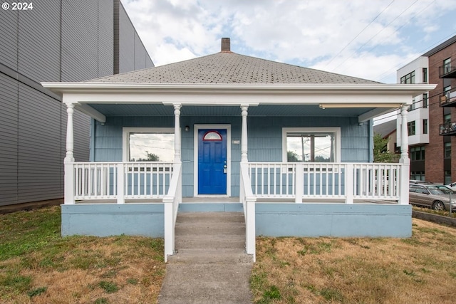 view of front of home featuring covered porch and a front yard