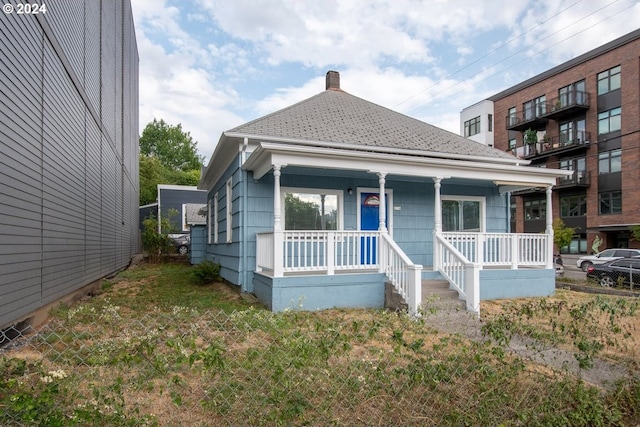 bungalow-style home featuring a porch and a front lawn