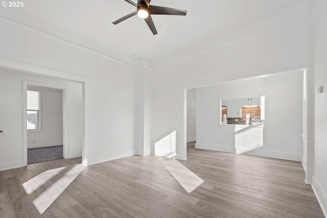 unfurnished living room with ceiling fan and wood-type flooring