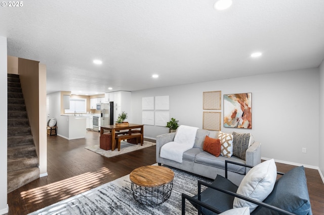 living room featuring dark hardwood / wood-style flooring, sink, and a textured ceiling