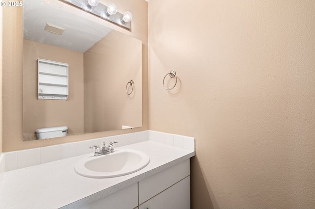 bathroom featuring vanity and toilet