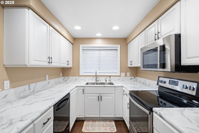 kitchen with dark wood-type flooring, appliances with stainless steel finishes, sink, and white cabinets