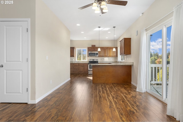 381 SE Regan Hill Loop, Estacada, OR 97023 - kitchen featuring appliances with stainless steel finishes, brown cabinetry, dark wood-type flooring, a ceiling fan, and a peninsula