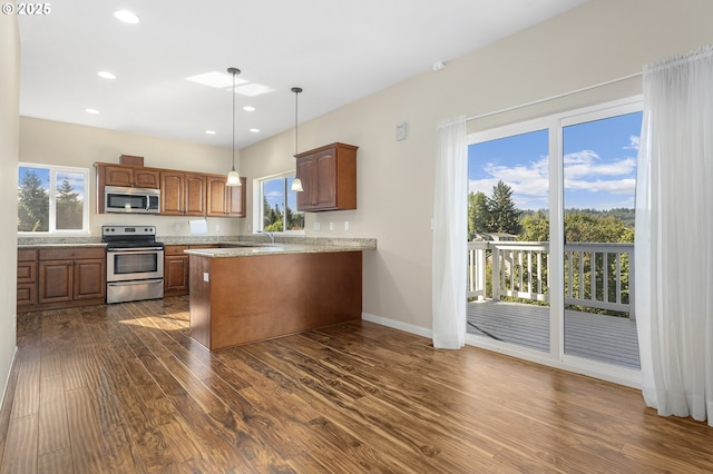 381 SE Regan Hill Loop, Estacada, OR 97023 - kitchen with appliances with stainless steel finishes, dark wood finished floors, a peninsula, healthy amount of natural light, and recessed lighting