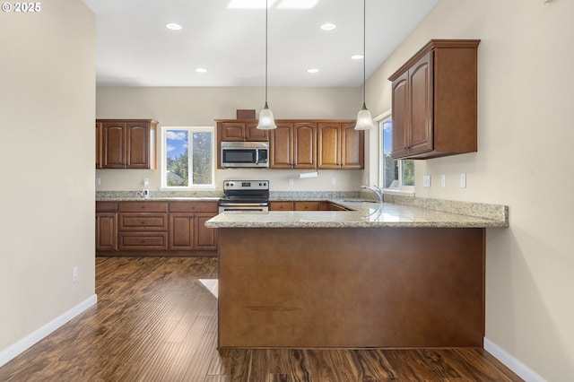 381 SE Regan Hill Loop, Estacada, OR 97023 - kitchen featuring appliances with stainless steel finishes, dark wood finished floors, a peninsula, light stone counters, and hanging light fixtures