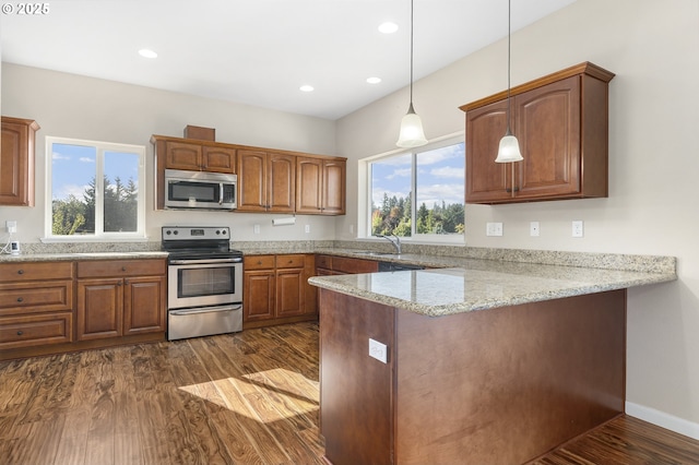 381 SE Regan Hill Loop, Estacada, OR 97023 - kitchen featuring stainless steel appliances, dark wood-style floors, a peninsula, brown cabinetry, and recessed lighting