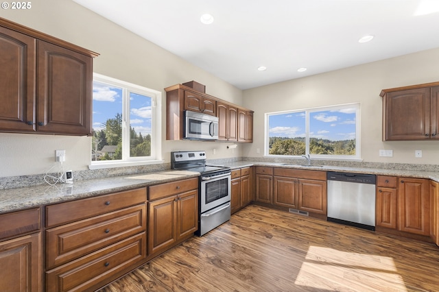 381 SE Regan Hill Loop, Estacada, OR 97023 - kitchen featuring appliances with stainless steel finishes, healthy amount of natural light, dark wood finished floors, light stone countertops, and recessed lighting
