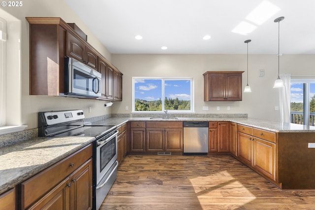 381 SE Regan Hill Loop, Estacada, OR 97023 - kitchen featuring stainless steel appliances, dark wood finished floors, a peninsula, light stone counters, and recessed lighting