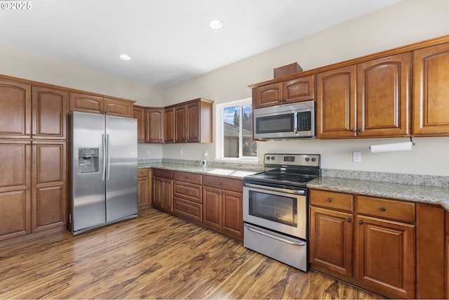 381 SE Regan Hill Loop, Estacada, OR 97023 - kitchen with appliances with stainless steel finishes, dark wood finished floors, light stone countertops, recessed lighting, and brown cabinets