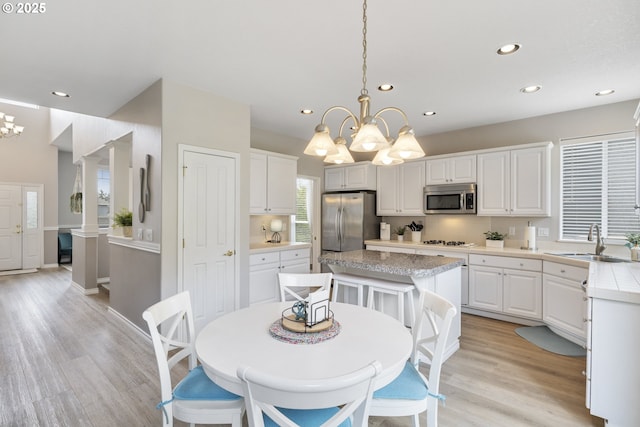 16205 SW Blackbird Dr, Beaverton, OR 97007 - kitchen with stainless steel appliances, a chandelier, a sink, light countertops, and white cabinets