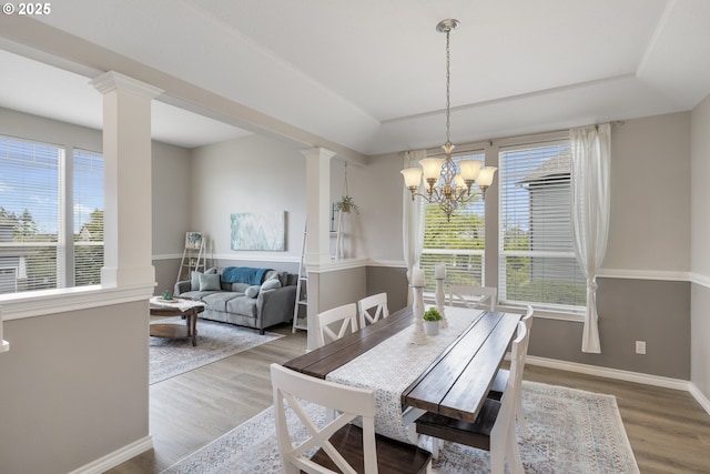 16205 SW Blackbird Dr, Beaverton, OR 97007 - dining area featuring wood finished floors, ornate columns, baseboards, and a chandelier