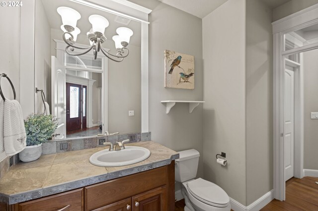 carpeted bedroom featuring a tray ceiling, a tile fireplace, ceiling fan, and ensuite bathroom