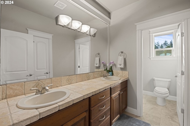 bathroom with tile patterned flooring, vanity, and toilet