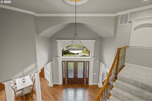 foyer featuring crown molding, french doors, and light wood-type flooring