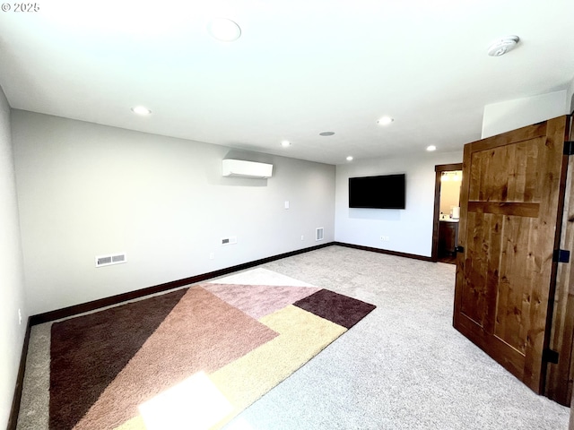finished below grade area with light colored carpet, a wall mounted AC, recessed lighting, and baseboards