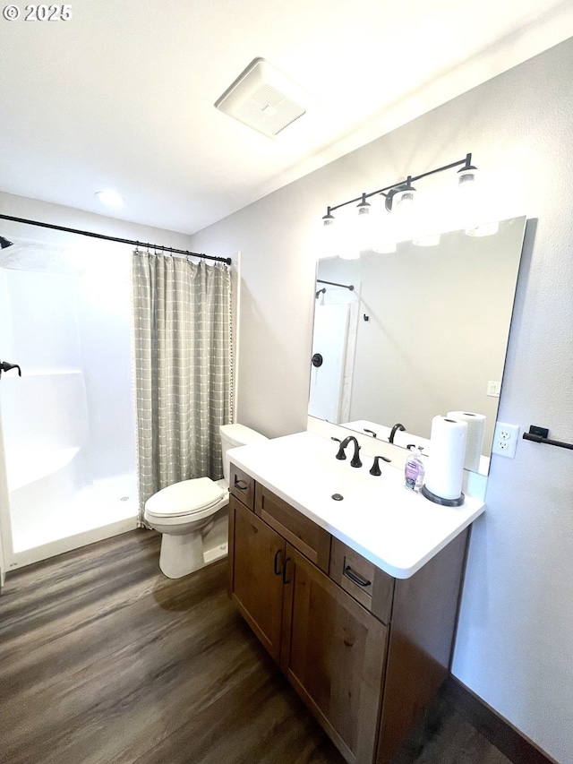 full bathroom featuring wood finished floors, a shower with curtain, toilet, and vanity