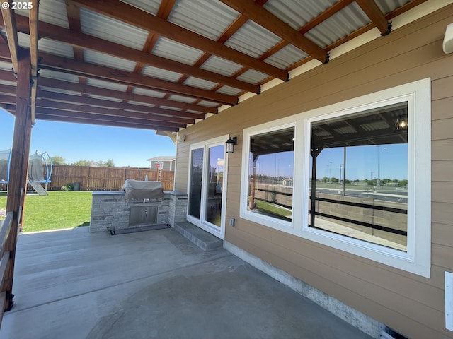 view of patio featuring a trampoline and exterior kitchen