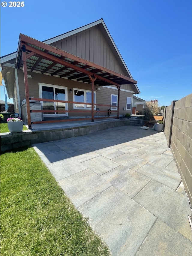 back of property featuring board and batten siding and fence
