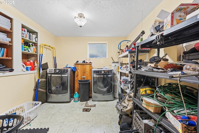 washroom featuring water heater, washer and clothes dryer, and a textured ceiling