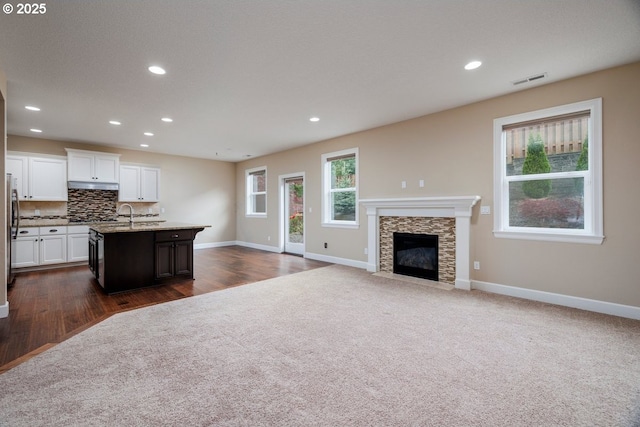 15997 NW Rossetta St, Portland, OR 97229 - kitchen featuring baseboards, an island with sink, recessed lighting, decorative backsplash, and white cabinets