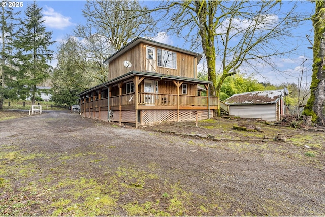 view of front of house with a shed, an outdoor structure, and a wooden deck