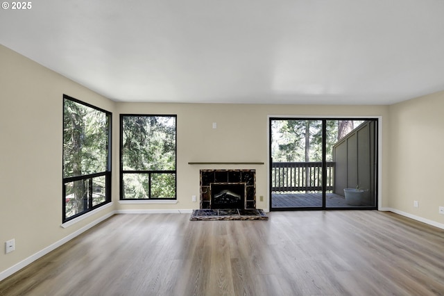 202 Trailside Loop, Eugene, OR 97405 - unfurnished living room with plenty of natural light, a tiled fireplace, and wood finished floors
