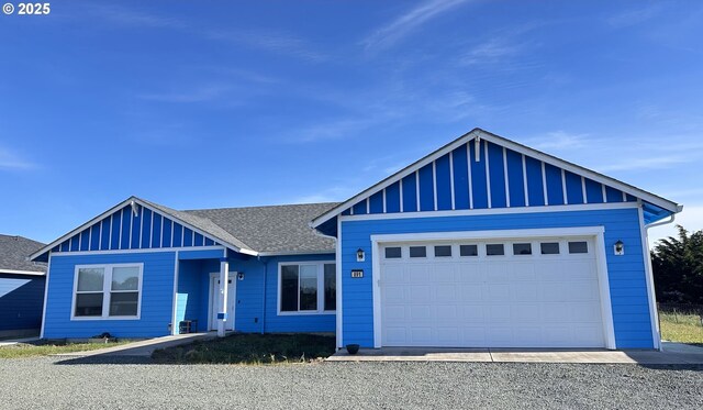 view of front facade featuring a garage, board and batten siding, a shingled roof, and gravel driveway