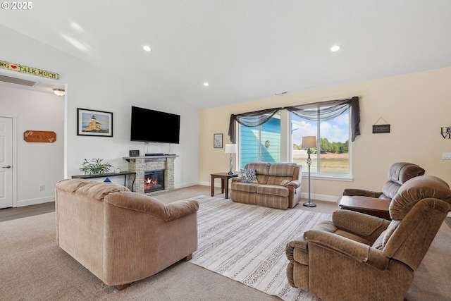 living area with a stone fireplace, vaulted ceiling, baseboards, carpet flooring, and recessed lighting
