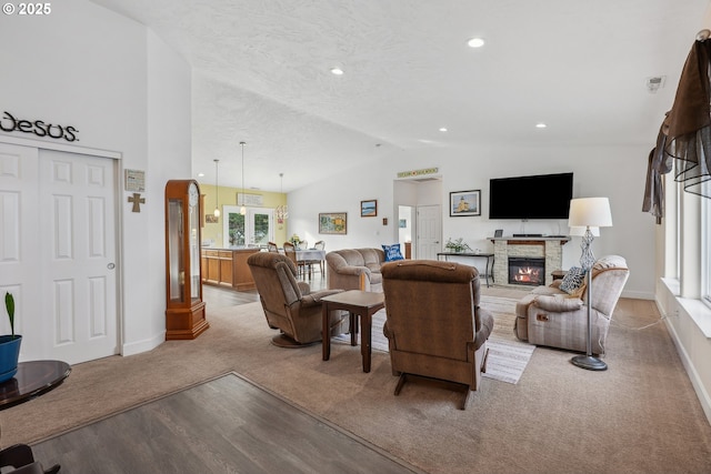 living room featuring light colored carpet, lofted ceiling, a stone fireplace, and a textured ceiling