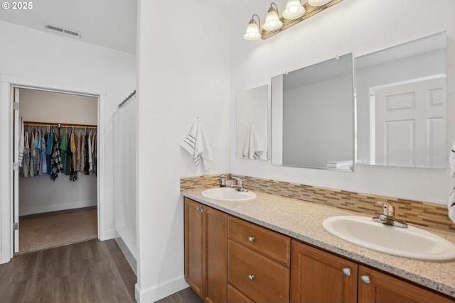 bathroom featuring vanity, wood-type flooring, and decorative backsplash